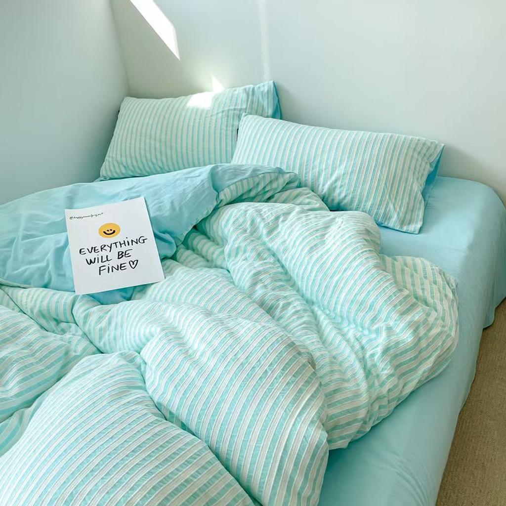 Top angle of blue striped duvet and pillows