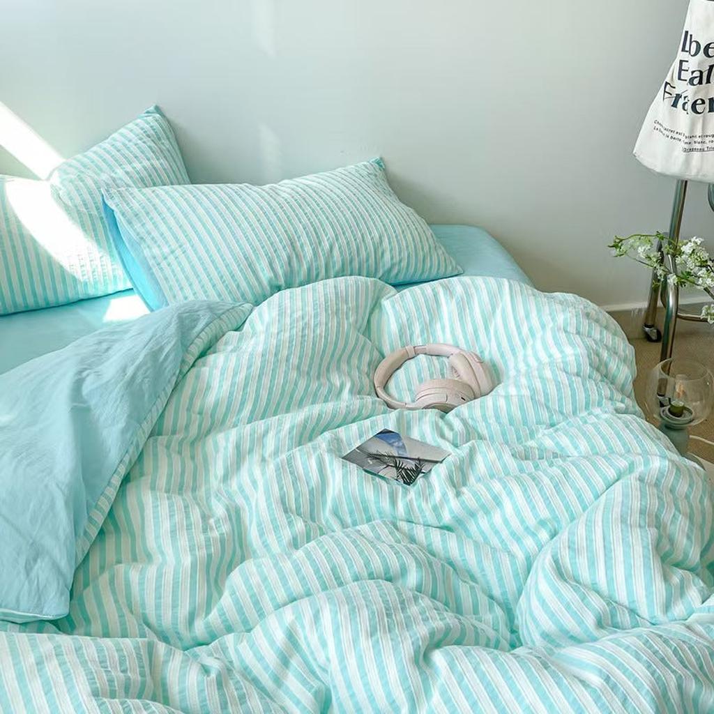 Refreshing blue jacquard striped cotton bedding styled on a sunlit bed